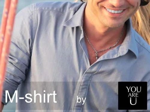 Camisa masculina azul-clara com fechos magnéticos, gola aberta, em homem sorrindo.