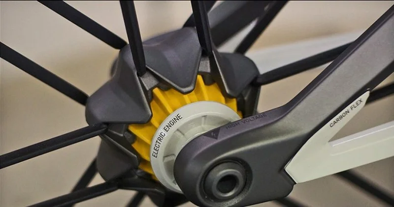 Canyon e-bike: detalhe do hub da roda com motor elétrico amarelo e suspensão Carbon Flex.