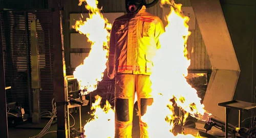 Tecido magnético em traje protetor de manequim imerso em chamas fortes, demonstrando resistência ao fogo. Não pega fogo.