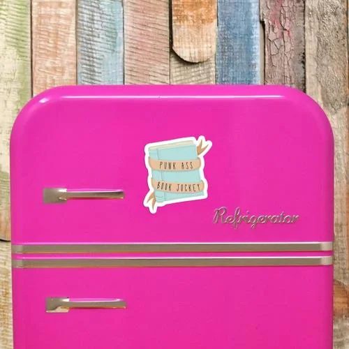 Ímã de geladeira Punk Ass Book Jockey para quem ama livros. Pilha de livros azuis em geladeira pink.