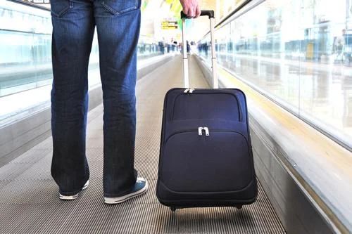 Mala de viagem retangular azul marinho em esteira rolante de aeroporto. Solução para malas transportadas facilmente.