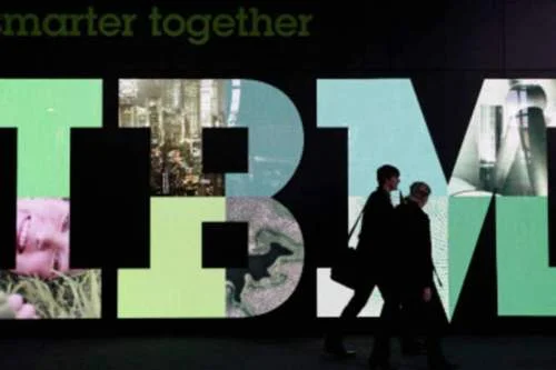 Logo IBM colorido com letras texturizadas, e duas pessoas em silhueta passando à frente. Texto smarter together.