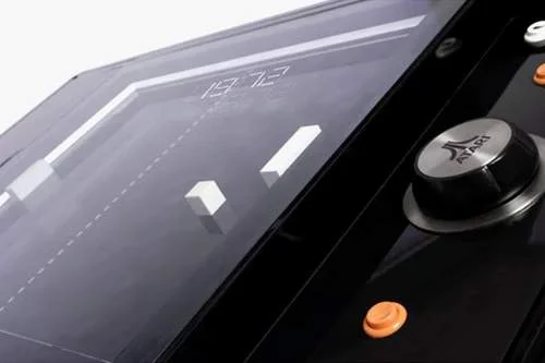 Mesa de centro com Pong embutido, jogo clássico Atari com paddles brancos e controle giratório.