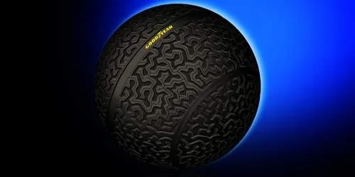 Pneu esférico Goodyear, preto com textura de rodagem, com brilho azul que evoca levitação magnética.
