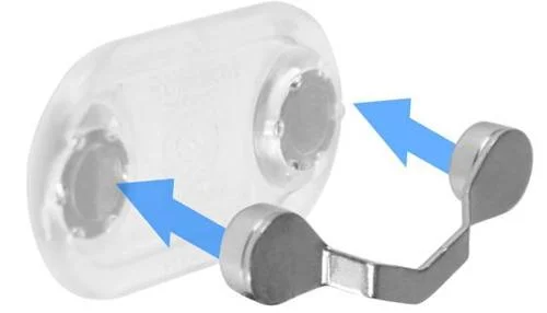 Suporte magnético para óculos. Base transparente alongada e suporte metálico em U com ímãs, setas azuis indicam encaixe.