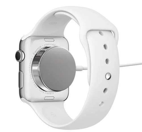 Apple Watch prateado com pulseira branca, vista traseira. O relógio da Apple é carregado por um disco magnético prateado.