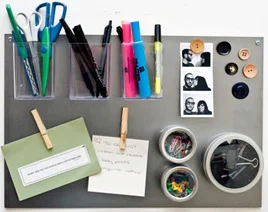 Quadro magnético com porta-canetas, notas com ímãs prendedores, fotos, botões e potes de clipes. Diversas utilidades para ímãs.